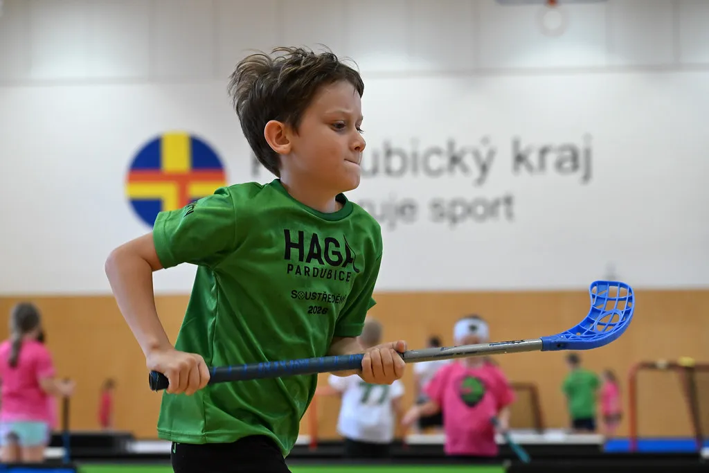 Kluk v zeleném triku HAGA s florbalkou